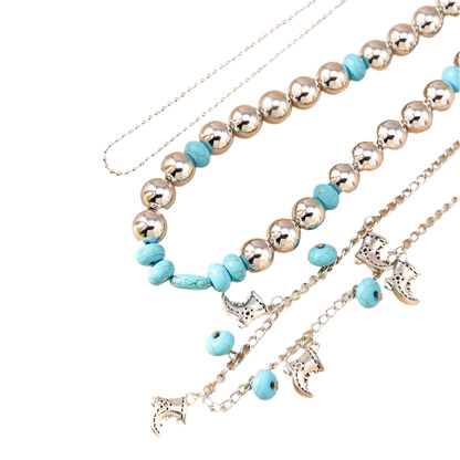 Necklace with blue beads and silver charms on a beige surface