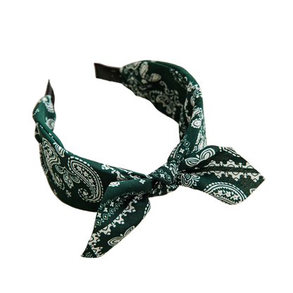 Green bandana headband on a beige tray with a cup and coaster in the background