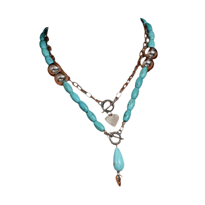 Turquoise beaded necklace with silver chain on a person wearing a white top.