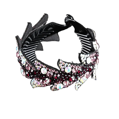 A black claw-style hair clip embellished with pink, red, and iridescent rhinestones, shown on a reflective black background.