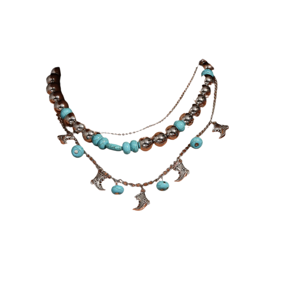 Necklace with turquoise beads and silver charms on a person wearing a white top.
