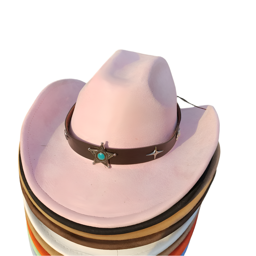 Stack of cowboy hats with a pink hat featuring a decorative band on a grassy background