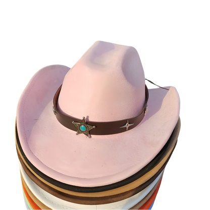 Stack of cowboy hats with a pink hat featuring a decorative band on a grassy background