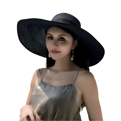 Woman wearing a black sun hat with a scenic background of ocean and sky.