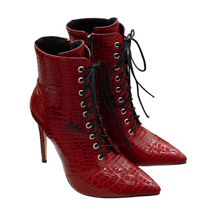 Red high-heeled boots with black laces on a white surface.