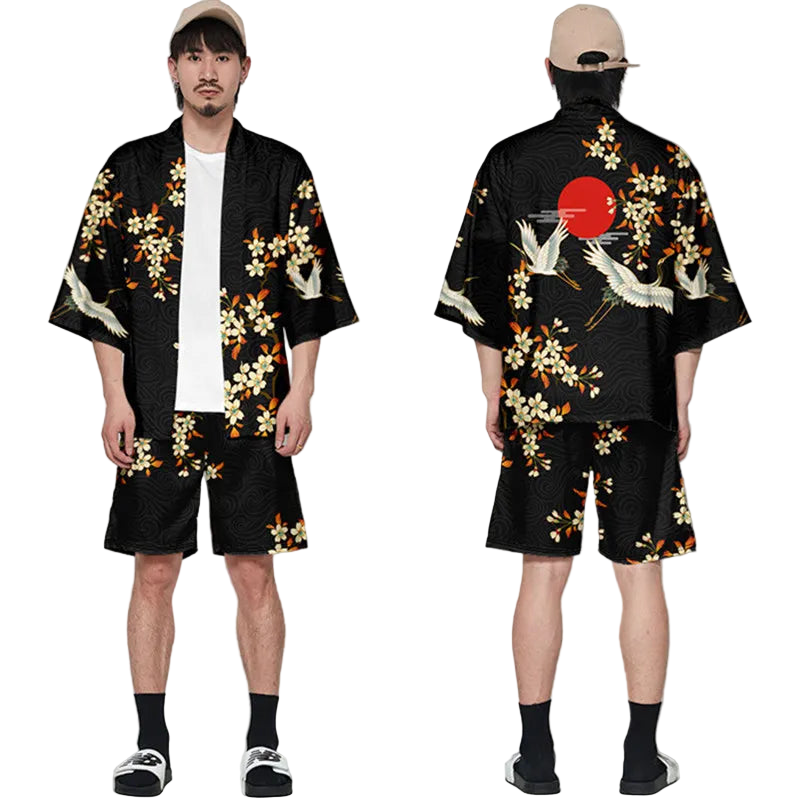 Person wearing a black kimono with floral and crane designs, standing against a white background.