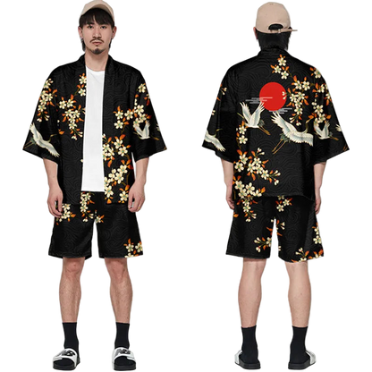 Person wearing a black kimono with floral and crane designs, standing against a white background.