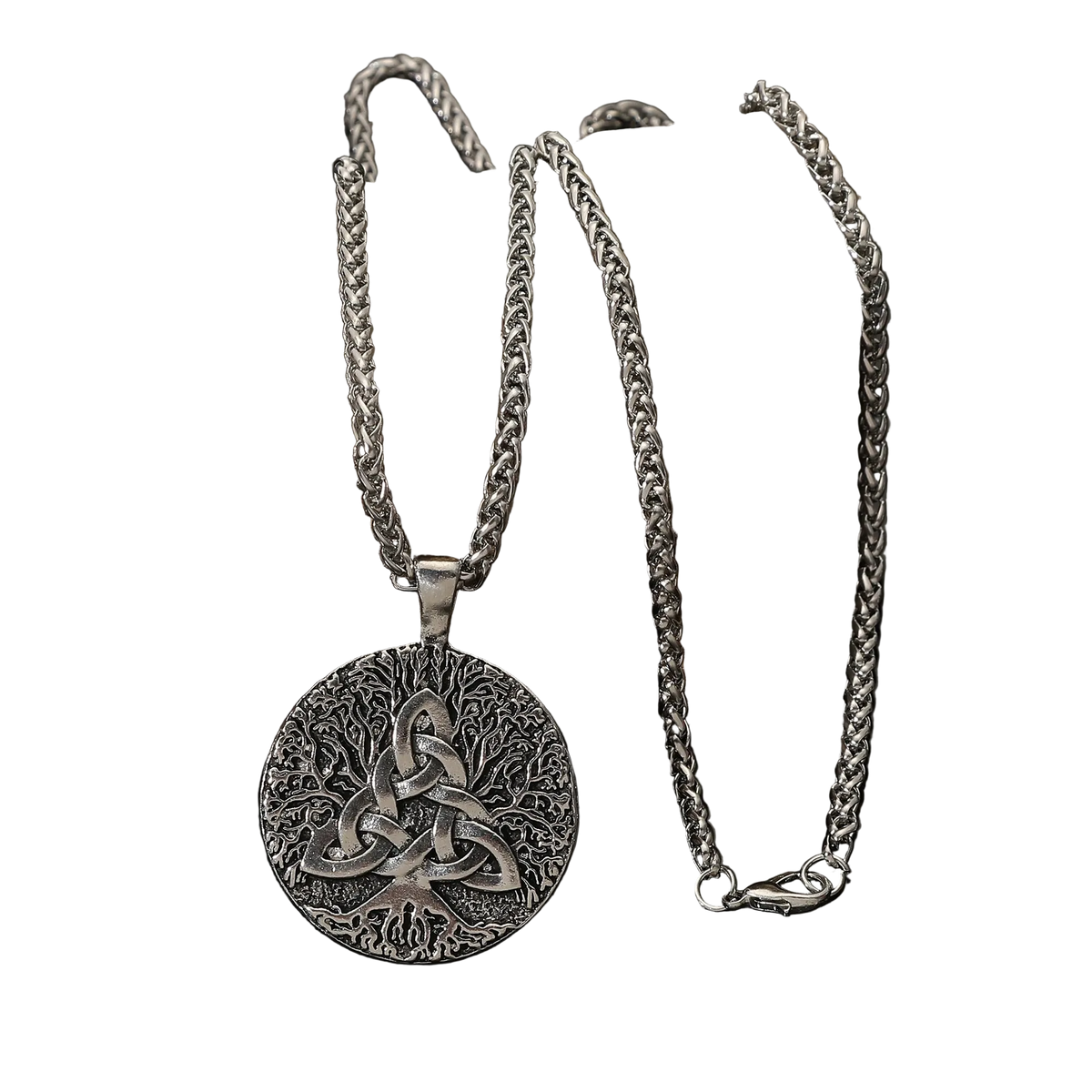 A silver Celtic knot pendant necklace with a triquetra design, displayed on a dark rock against a black reflective surface.