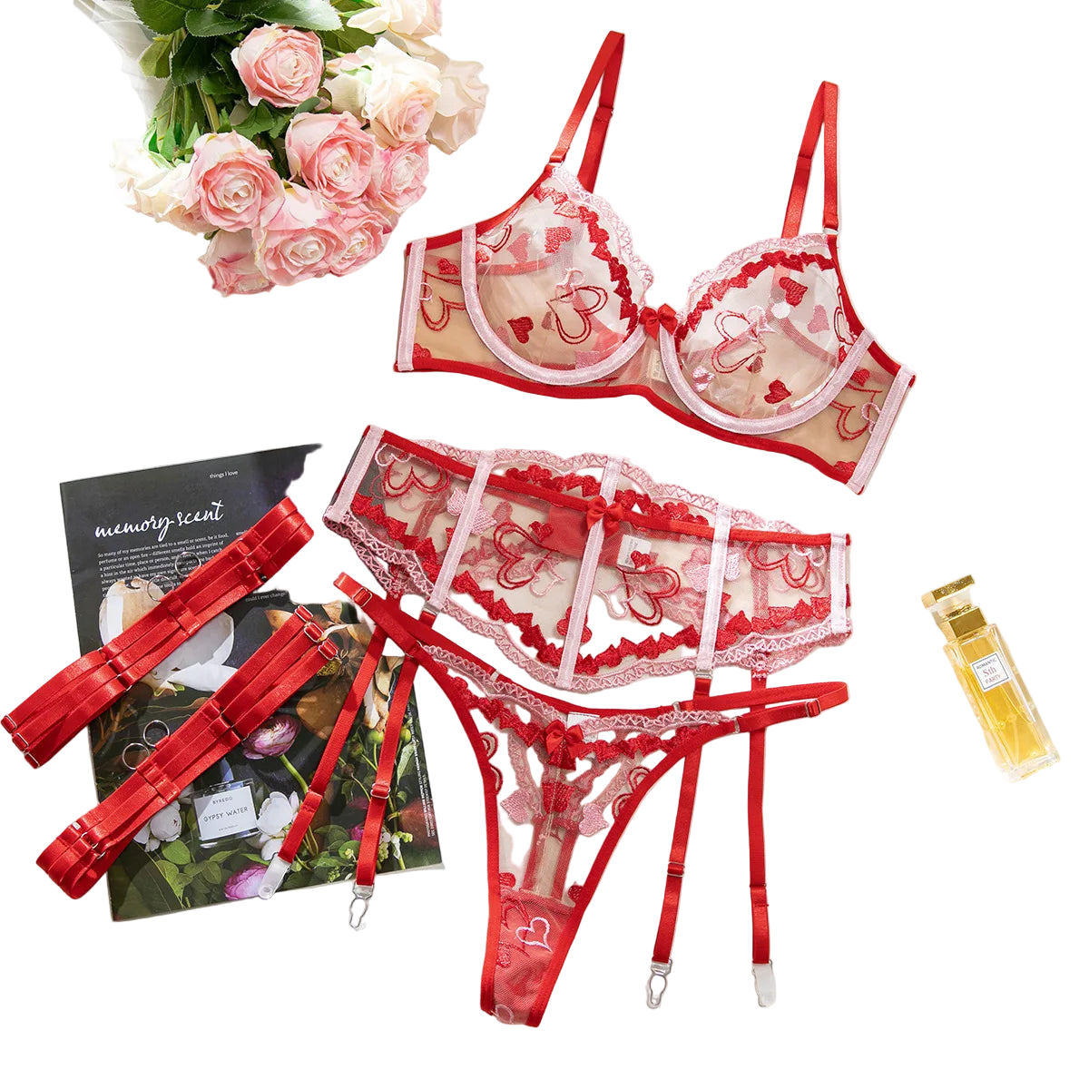 Red lace lingerie set with flowers and a magazine on a white surface