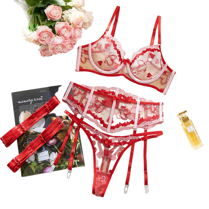 Red lace lingerie set with flowers and a magazine on a white surface