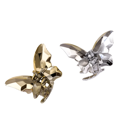 Gold and silver butterfly-shaped hair clips on a white fabric background
