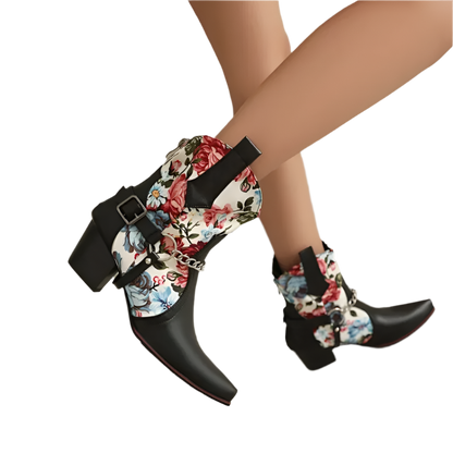 Black pointed-toe boots with floral pattern and buckles on a neutral background