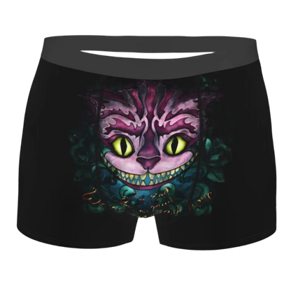 boxer shorts featuring the Cheshire Cat design from Alice in Wonderland, with glowing turquoise eyes and distinctive grinning teeth illuminated against a dark background.