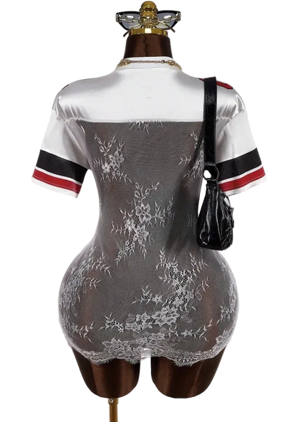 Mannequin wearing a white lace dress with black and red accents on a plain background