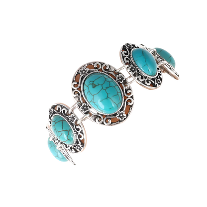 Turquoise stone bracelet with silver detailing on a mannequin arm