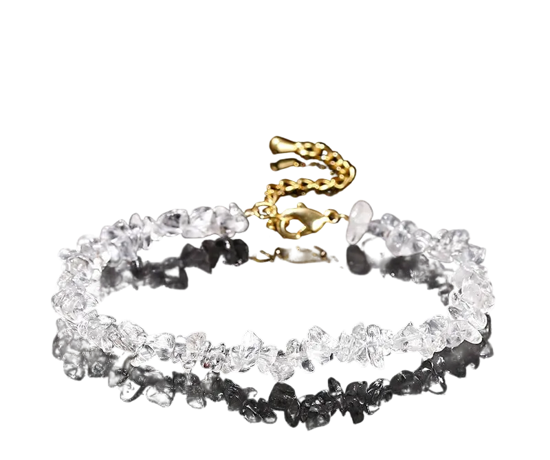 Natural rock quartz bracelet with gold chain on a black background