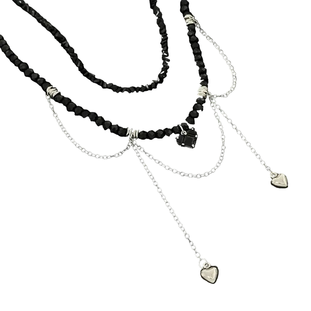 A layered necklace featuring black faceted beads, silver chain drapes, and small heart-shaped charms, displayed on a dark textured surface.