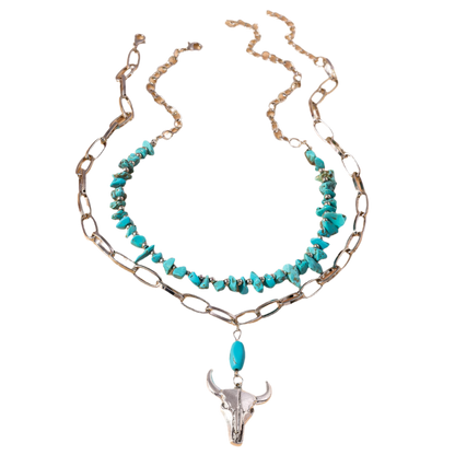Necklace with turquoise stones and bull head pendant on a beige background