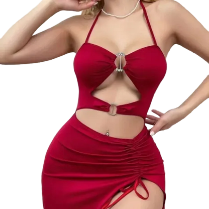 A woman wearing a red halter-neck bodycon dress with cutouts and ruching, posed indoors in a bedroom setting.
