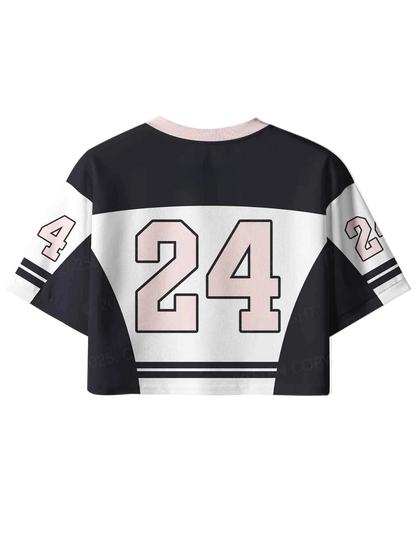 A cropped short-sleeve jersey top shown from the back, featuring a black body with a wide white horizontal stripe across the upper back, large pale pink number 24 outlined in black, and smaller matching numbers on the sleeves.