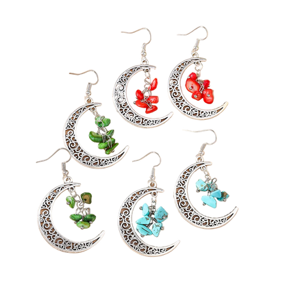 Set of moon-shaped earrings with floral and butterfly designs on a beige background