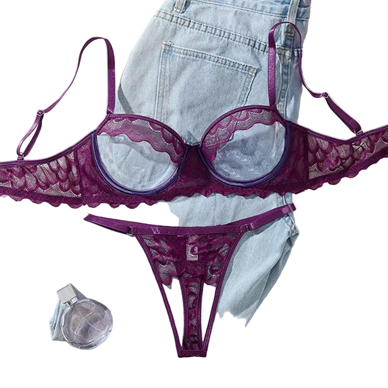Purple lace lingerie set on a light blue denim fabric background with a perfume bottle and flowers.