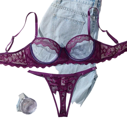 Purple lace lingerie set on a light blue denim fabric background with a perfume bottle and flowers.