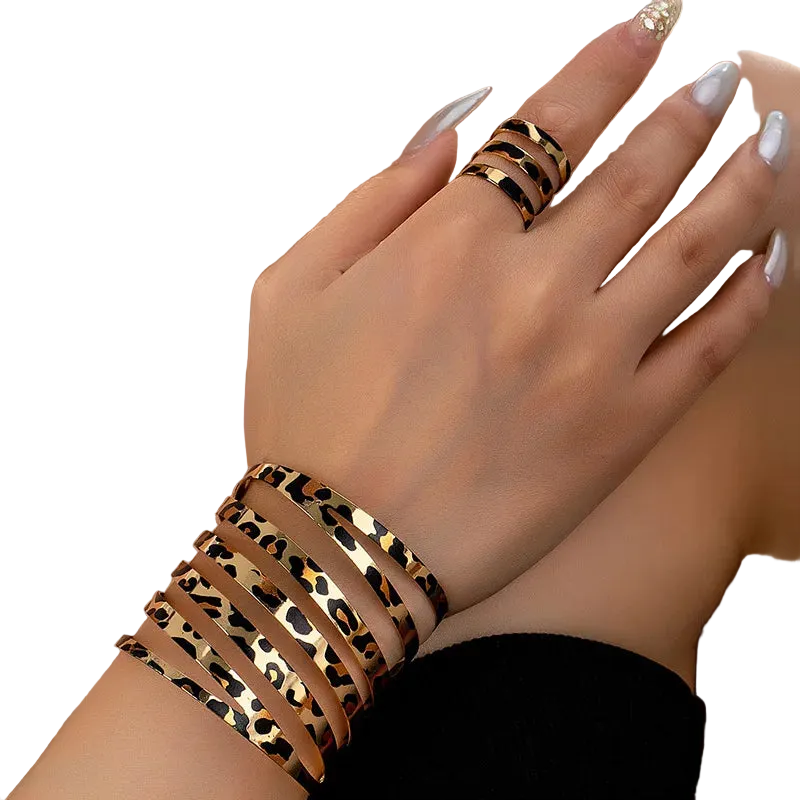 Leopard print bracelet and ring on a hand with a blurred background