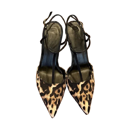 Pair of leopard print shoes on a wooden surface