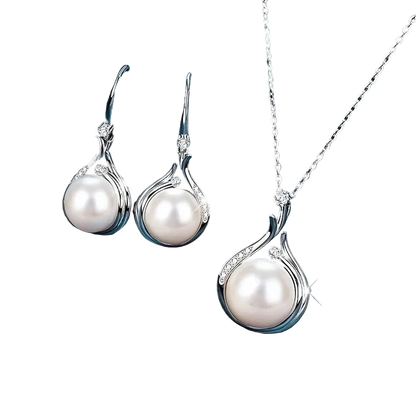 Silver-tone pearl jewelry set including a pendant necklace and matching drop earrings, displayed on a dark blue satin fabric background.