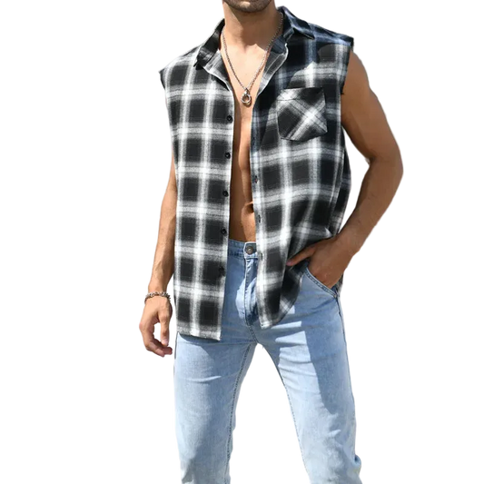 Man wearing a black and white checkered sleeveless shirt and light blue jeans standing on steps.