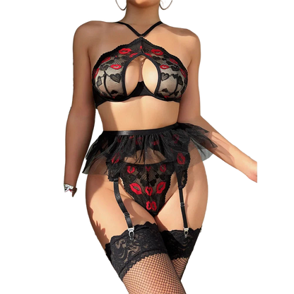 Person wearing a black lace lingerie set with red floral details, standing against a neutral background.