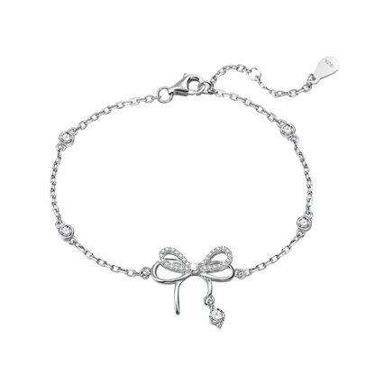 Silver bracelet with bow charm on a white background