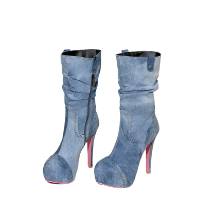 Pair of blue high-heeled boots with red soles on a beige background