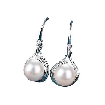 Pearl earrings with silver hooks on a dark blue fabric background
