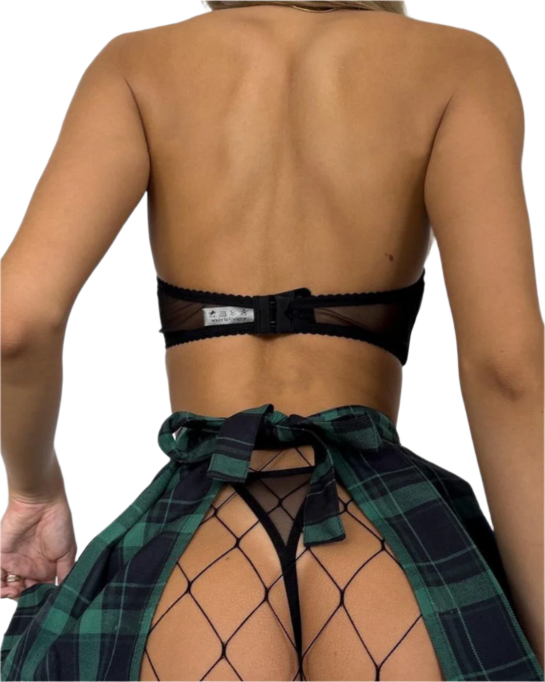 Person wearing a black bra and green plaid sarong on a plain background