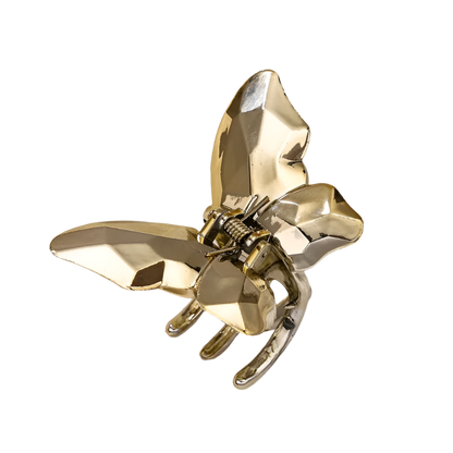 Gold bee-shaped hair clip on a white background