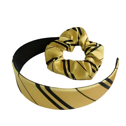 Gold headband with black stripes and matching scrunchie on a white background