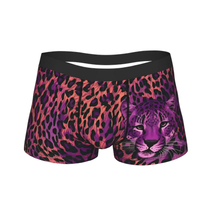 A pair of women's boxer briefs featuring a vibrant pink, purple, and black leopard print pattern with a detailed purple cheetah graphic on the right leg, set against a plain white background.