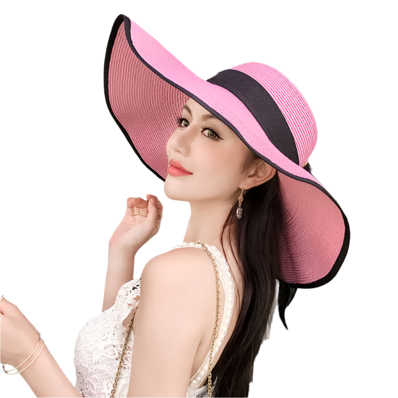 Woman wearing a large pink and black hat in an indoor setting