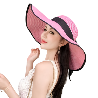 Woman wearing a large pink and black hat in an indoor setting