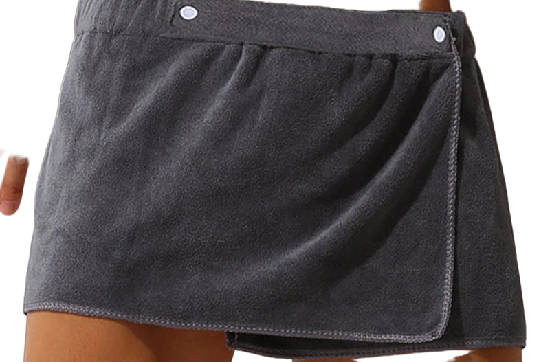 Gray towel skirt draped over a person's waist against a neutral background