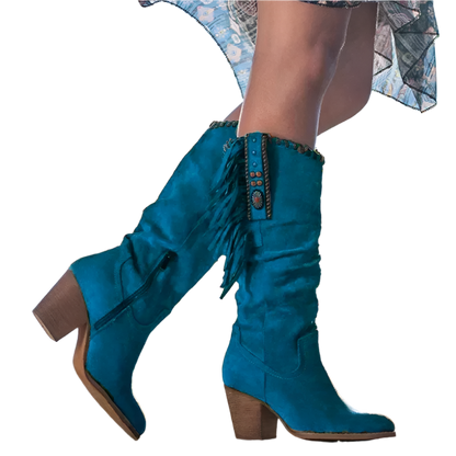 Teal knee-high boots with fringe details on a blurred outdoor background