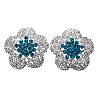 Pair of floral earrings with blue and silver design on a black background