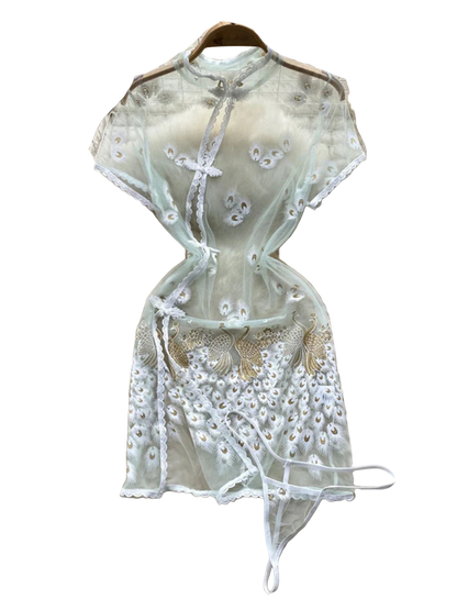 Light green embroidered top on a fur surface with floral decorations in the background