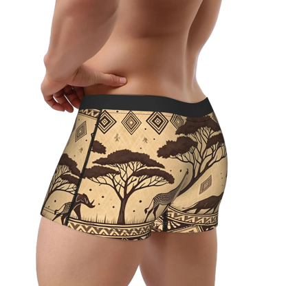 A close-up of a male model's lower torso wearing boxer briefs with a beige and brown African safari print featuring acacia trees, antelope, and geometric patterns, set against a plain white background.