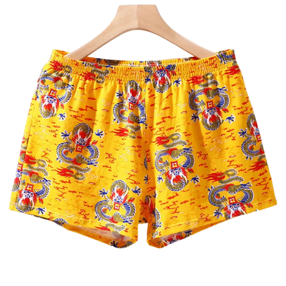 Yellow boxer shorts with dragon pattern on a hanger against a white background