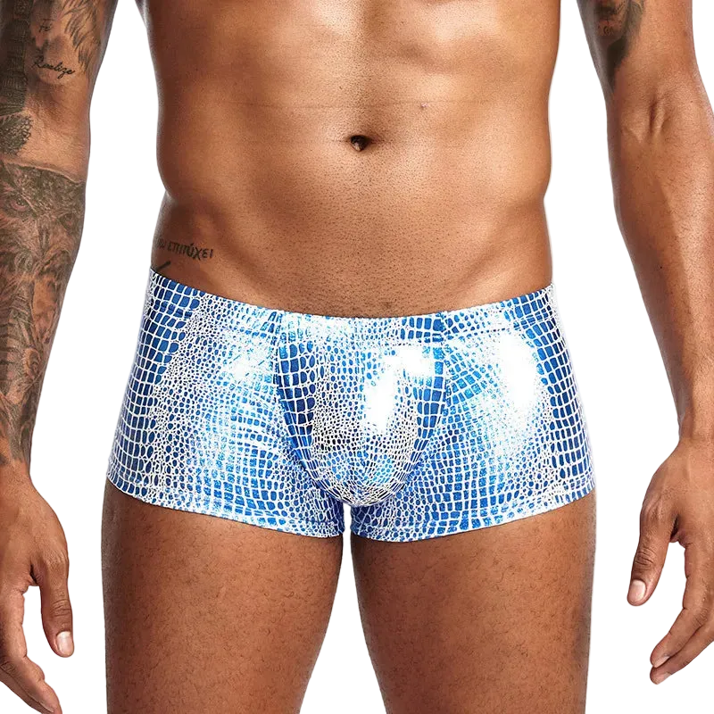 Blue patterned swim shorts worn by a person on a white background