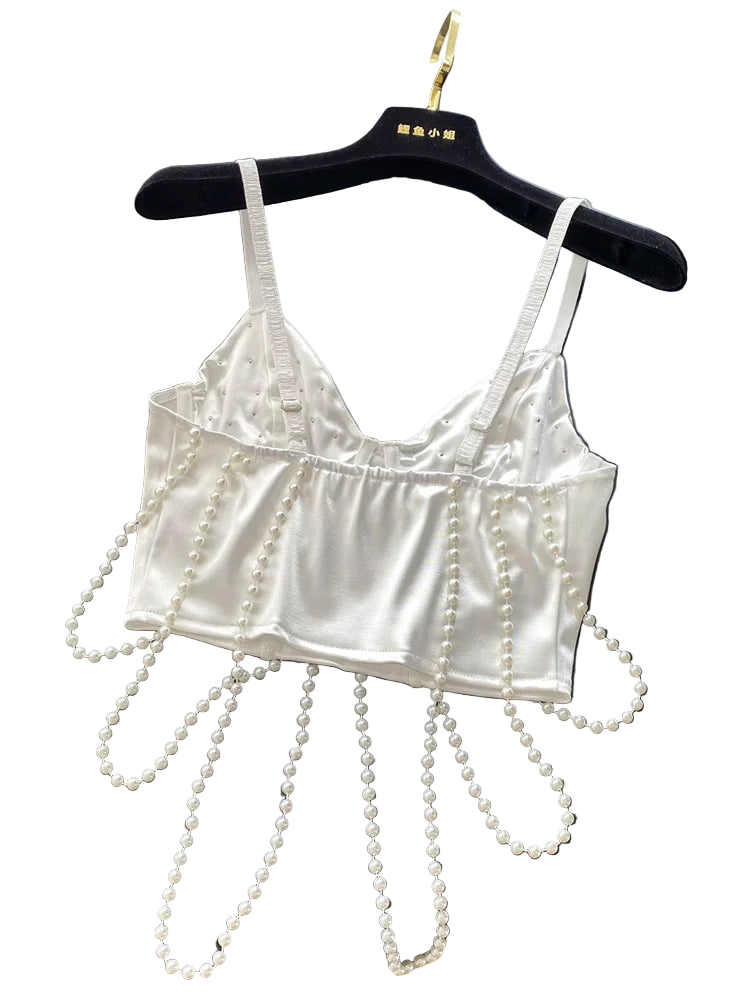 White satin bralette with pearl embellishments on a black surface