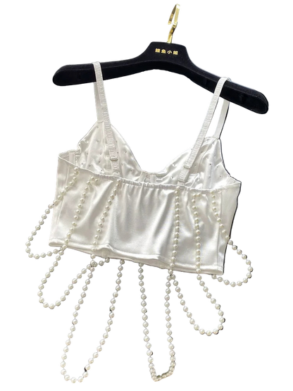 White satin bralette with pearl embellishments on a black surface